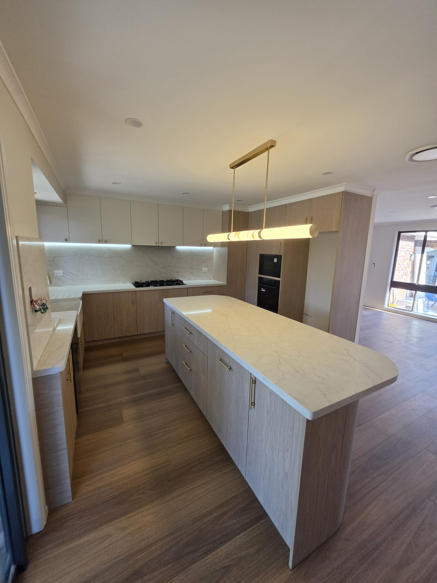 Modern kitchen with island bench, stone benchtop and timber cabinetry