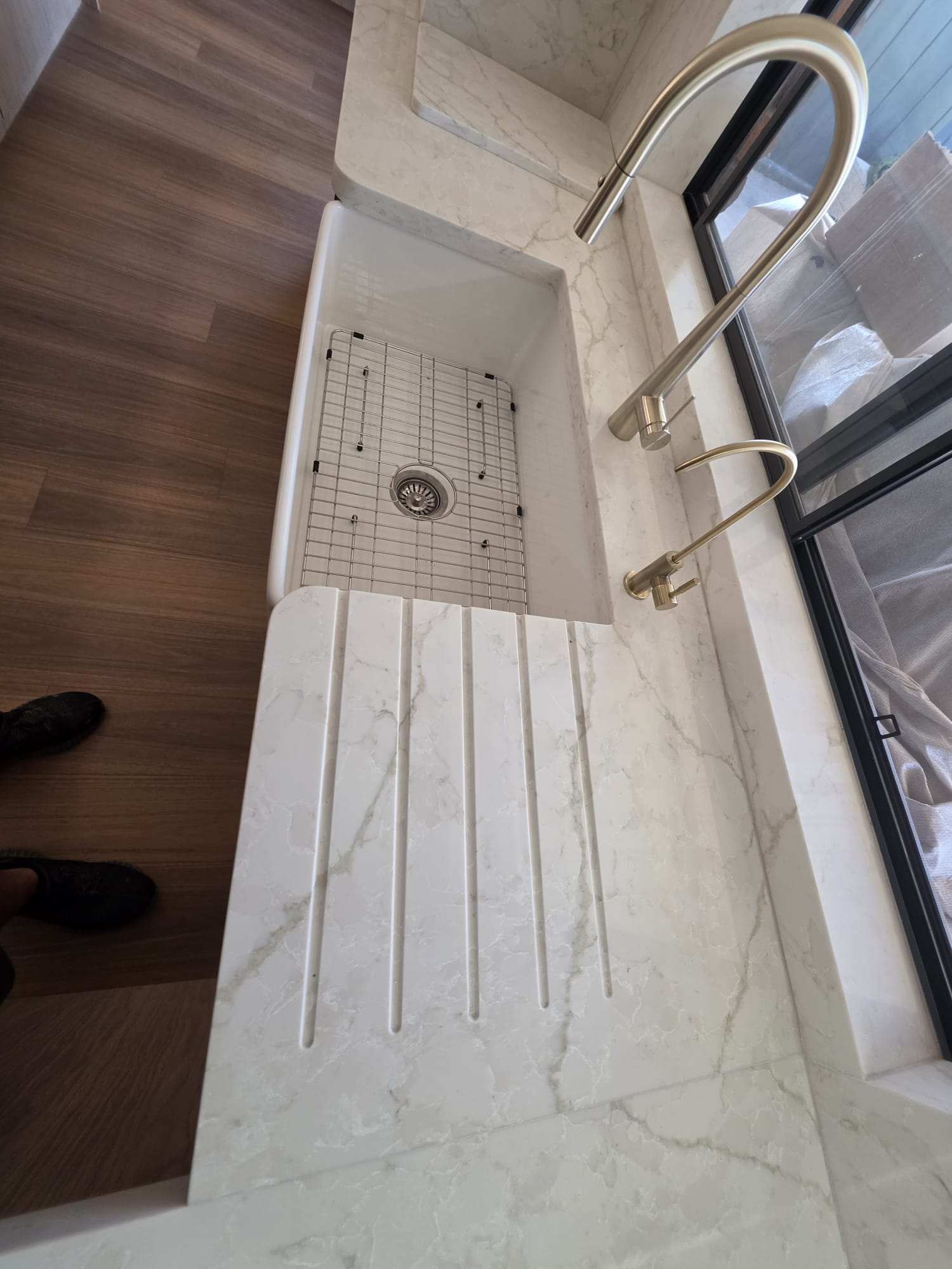 Marble benchtop with butler's sink and brushed brass tapware